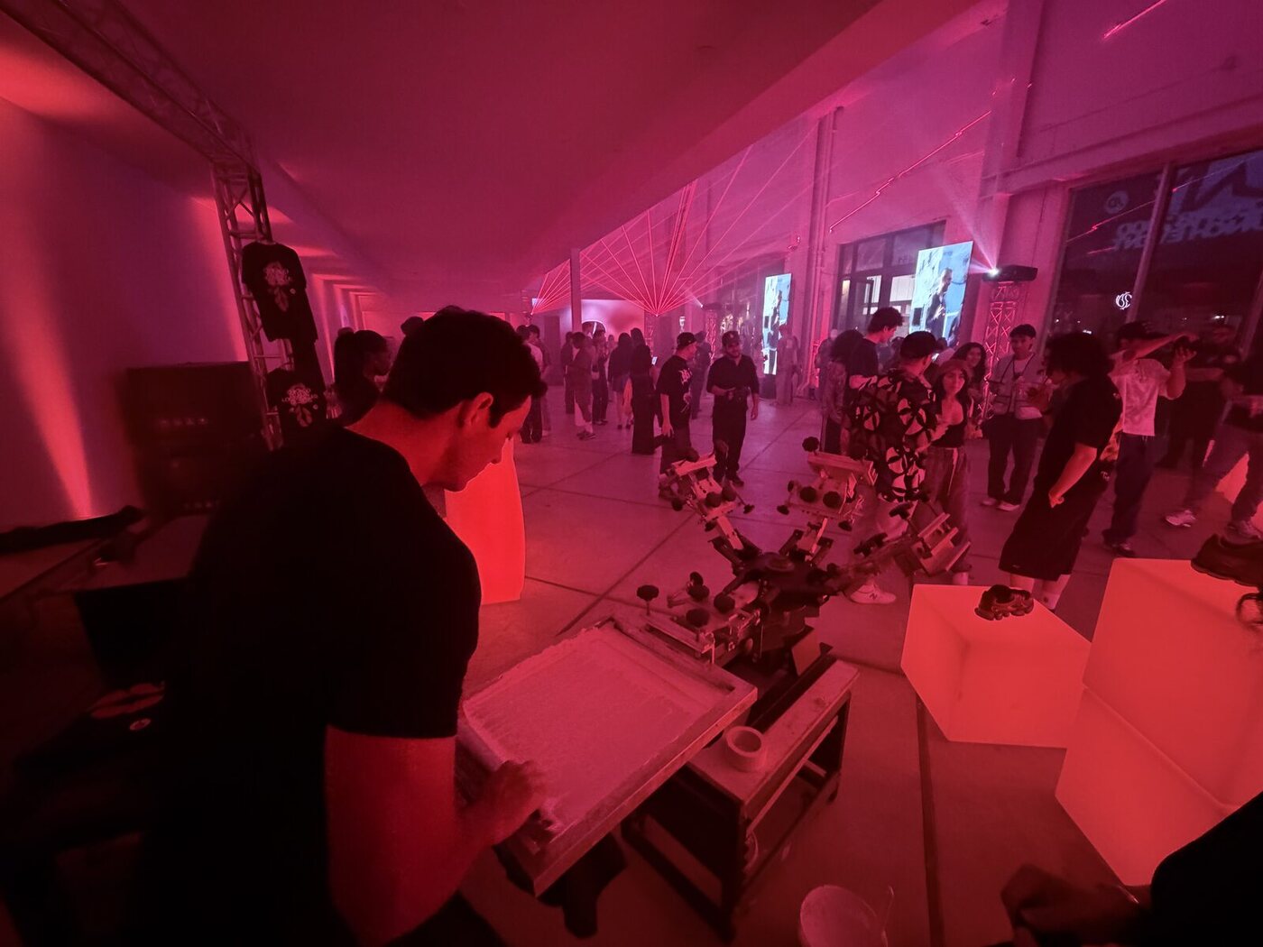 Guests filling a brand activation footprint around a live merch station